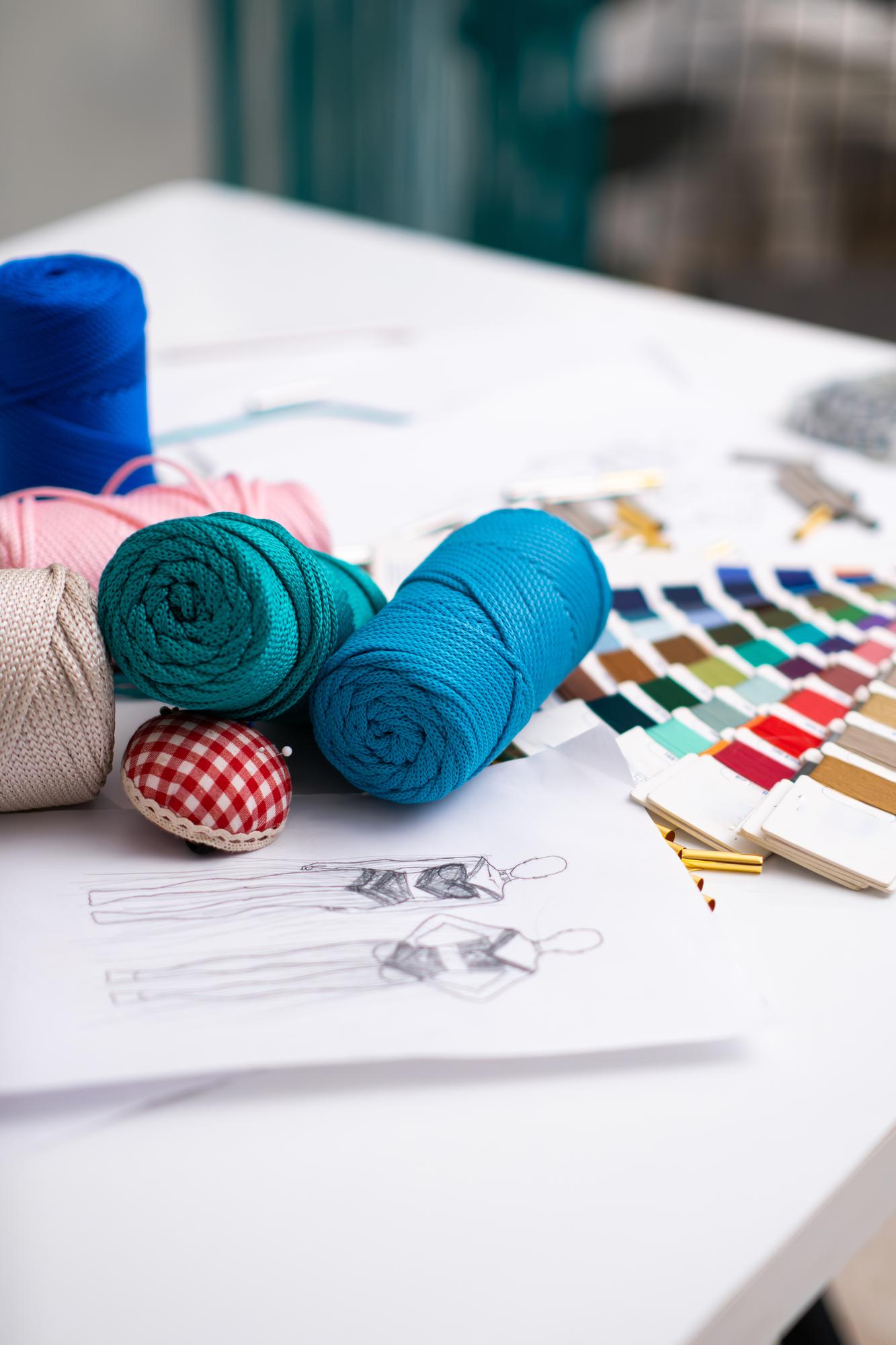 Atelier Arbeitsfläche mit Garnspulen und Skizzen
